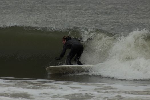 Surfer skillfully navigating a wave, showcasing thrilling water sports adventure.