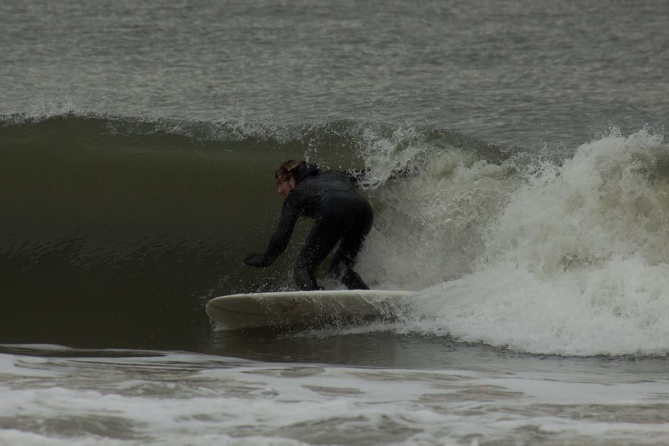 Surfer skillfully navigating a wave, showcasing thrilling water sports adventure.