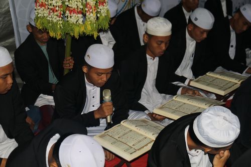 Free Men in traditional attire reading religious texts during a prayer gathering indoors. Stock Photo