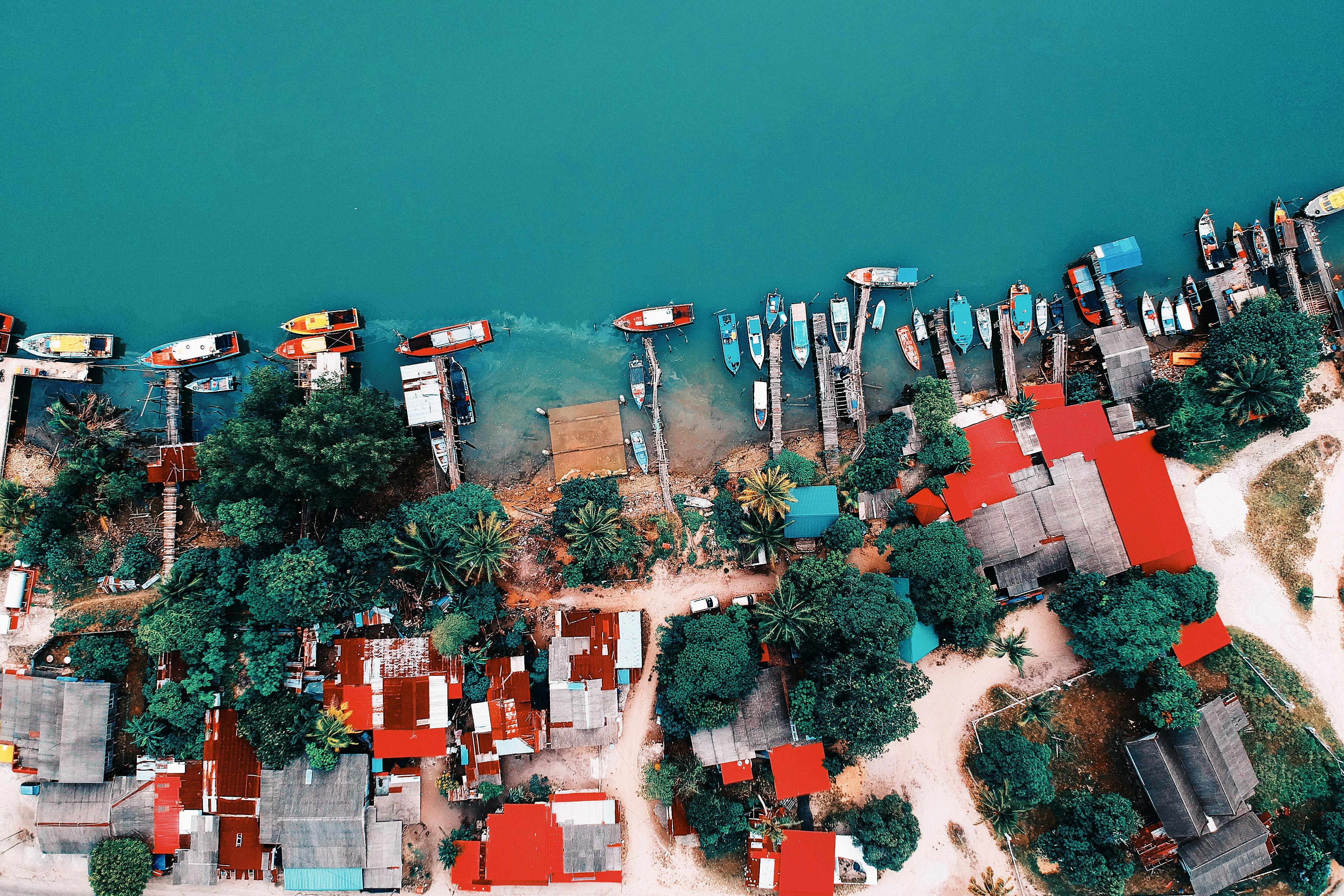 Aerial photography of a vibrant waterfront in Chukai, Terengganu displaying boats and colorful rooftops.
