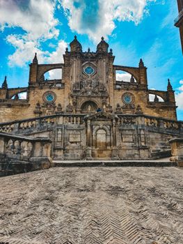 Low-angle shot of the stunning Jerez Cathedral in Spain, capturing its Gothic architecture against a vivid blue sky.