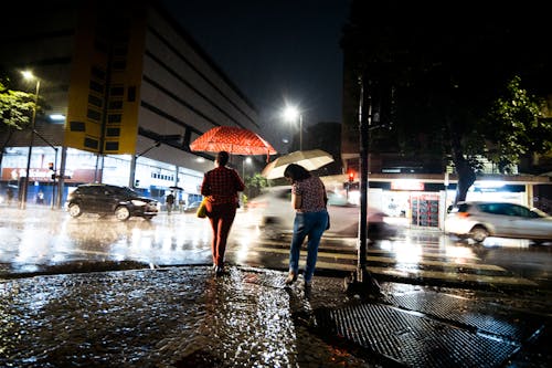 Women with Umbrellas Standing on Sidewalk