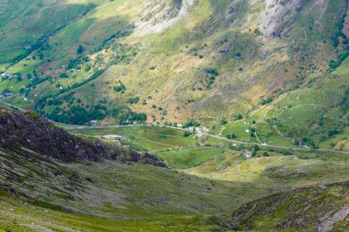 Free Explore the lush greenery of this remote mountain valley, showcasing winding roads and vibrant landscapes. Stock Photo