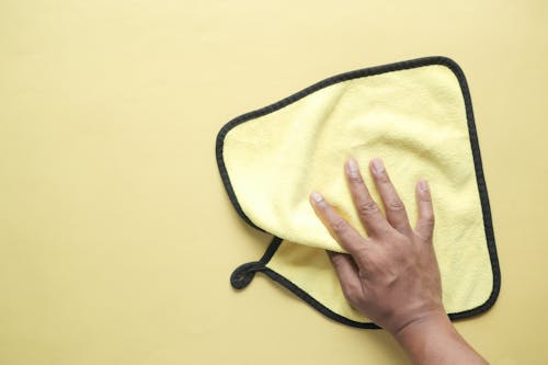 Hand Holding a Yellow Microfiber Towel