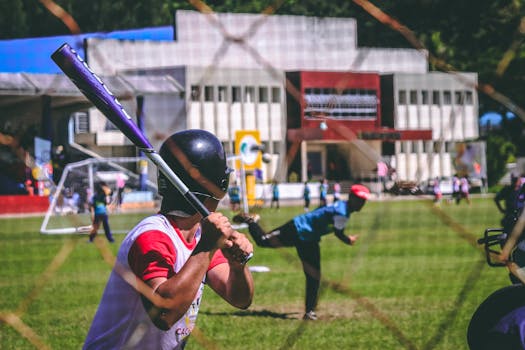 Action shot of a youth baseball game in the Philippines with focus on the batter and pitcher.