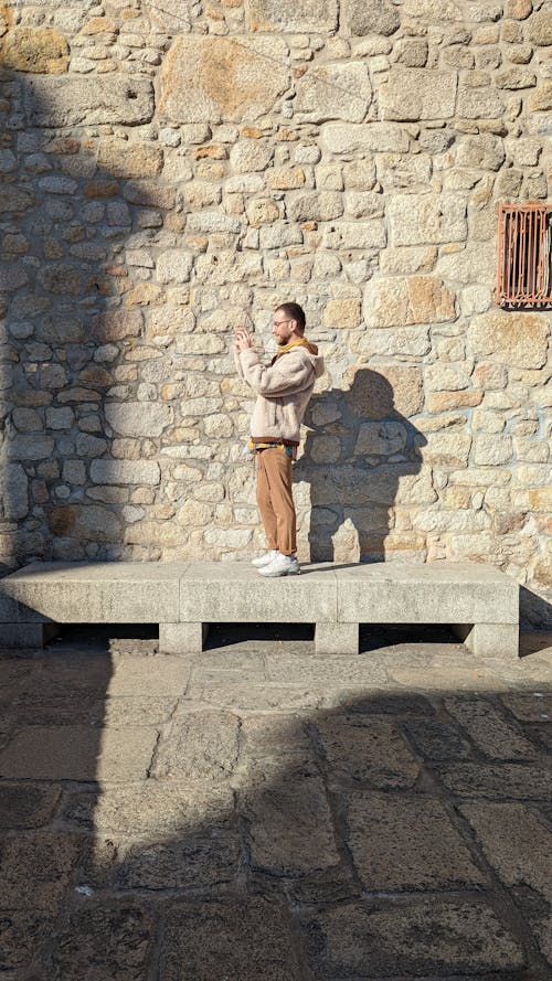 Free Man in Brown Pants Sitting on Gray Concrete Bench Stock Photo