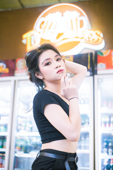 Young woman poses confidently indoors in Bandung store, West Java, Indonesia.