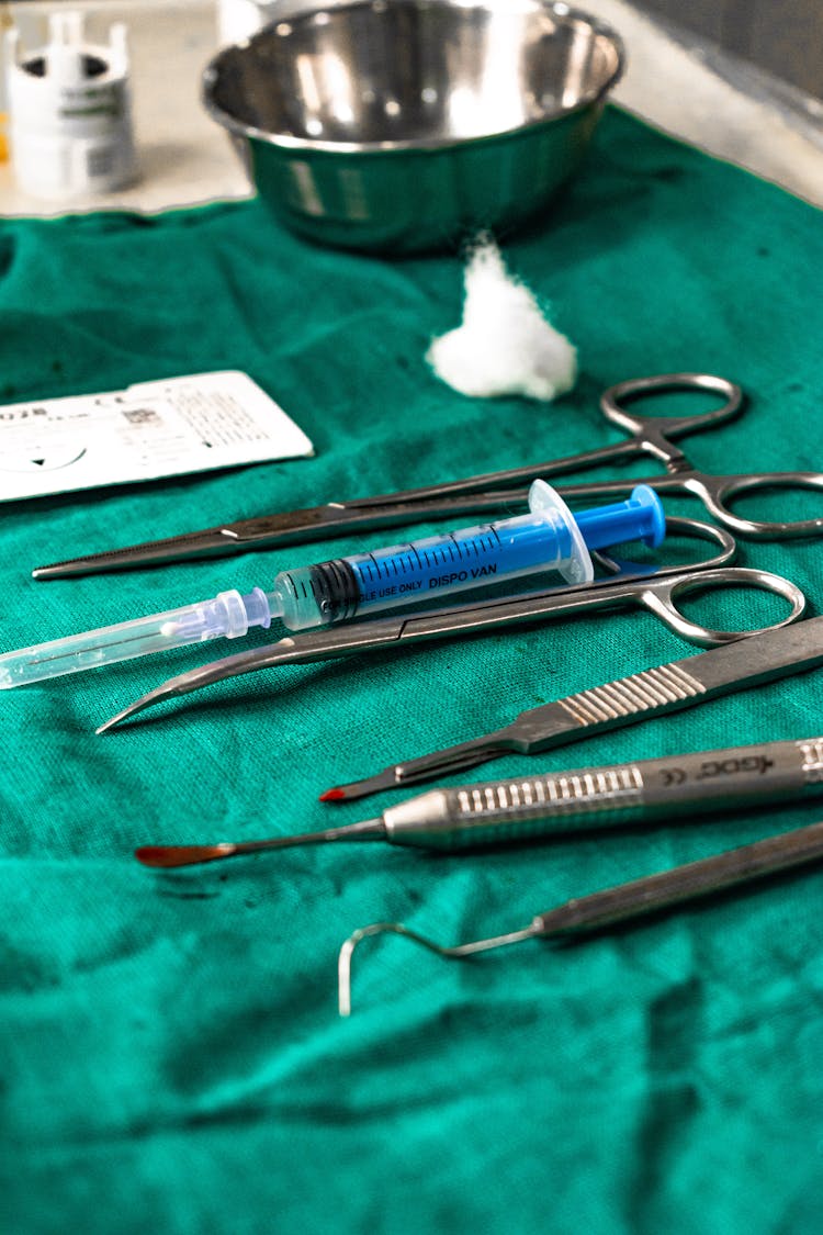 Medical Tools And Syringe Over A Green Cloth