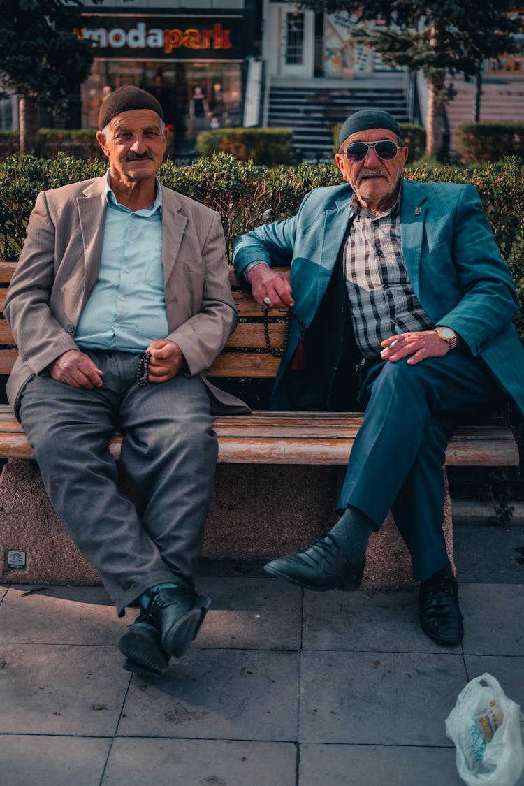 Men On Coats Sitting On A Bench