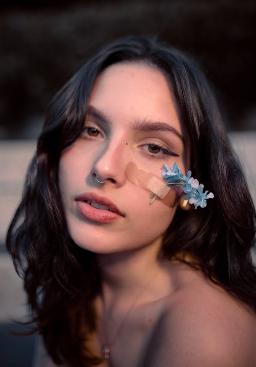 Woman with Flowers and Adhesive Bandage on Her Face