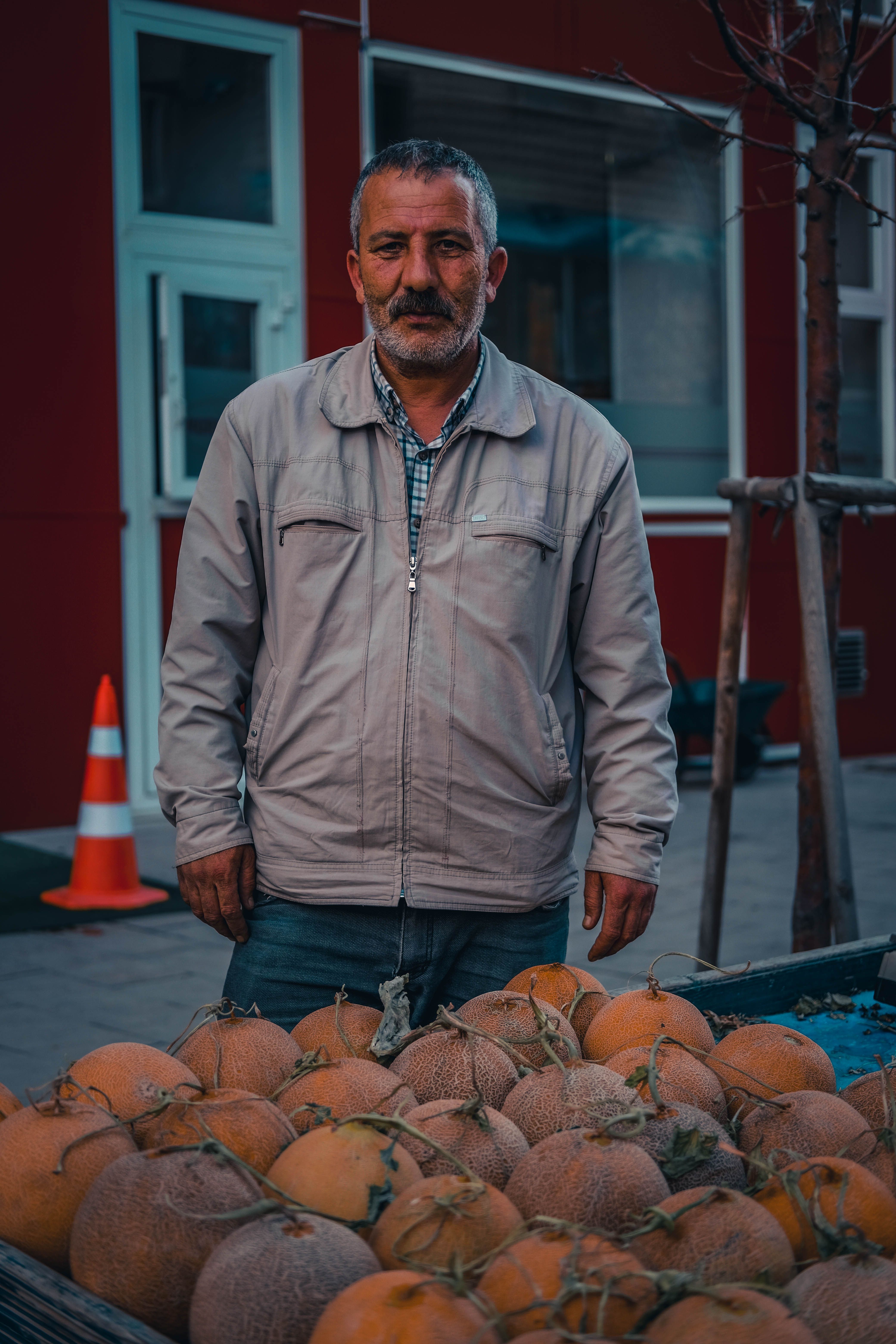 Portrait of a vendor selling fresh melons in Erzurum, Turkey, with rustic market vibes.