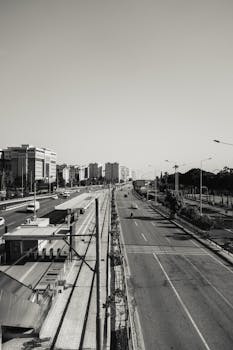 A high angle view of an empty city street with surrounding buildings in a monochrome setting.