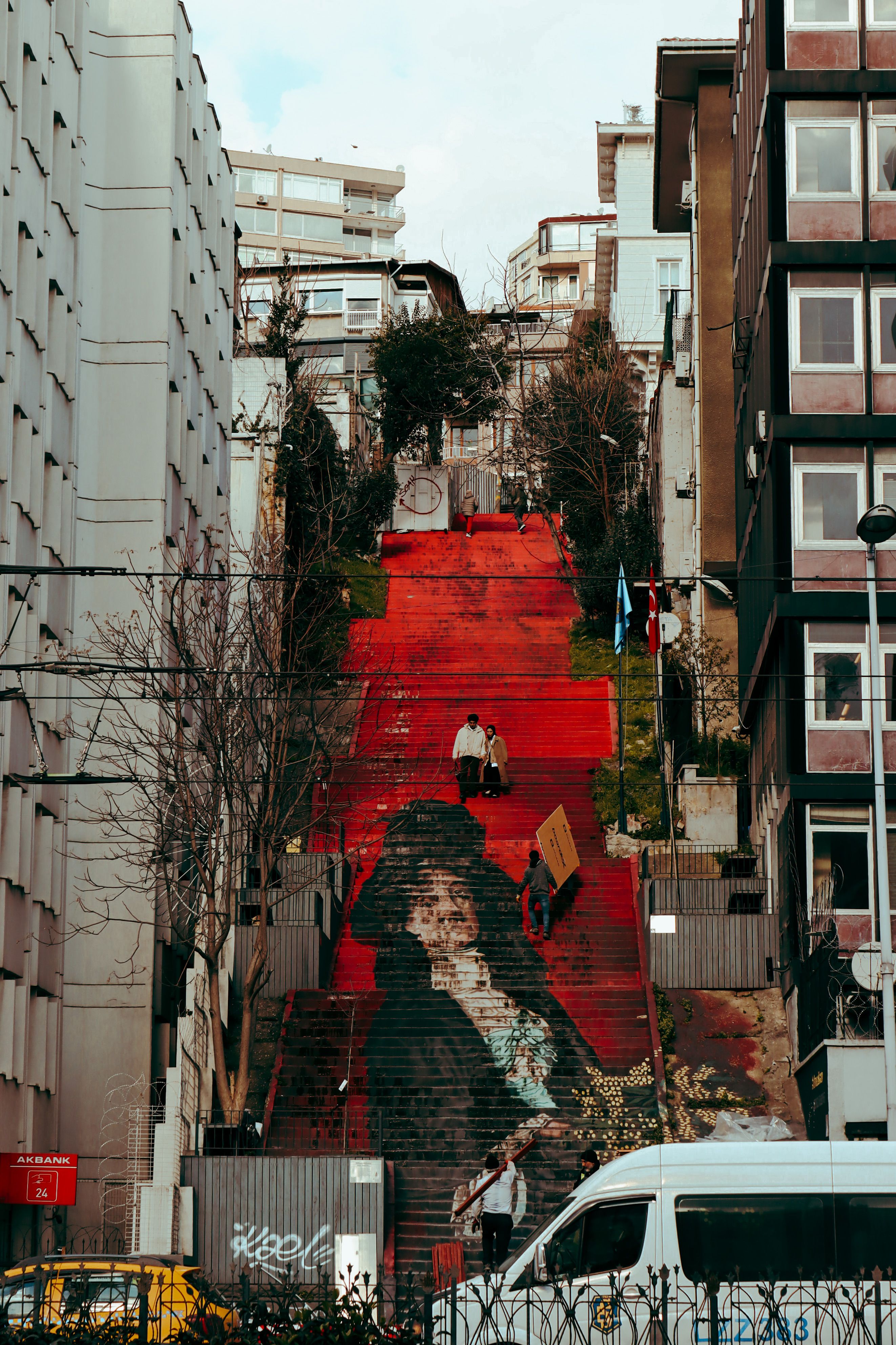 Vibrant red stairs with street art in Istanbul's cityscape.