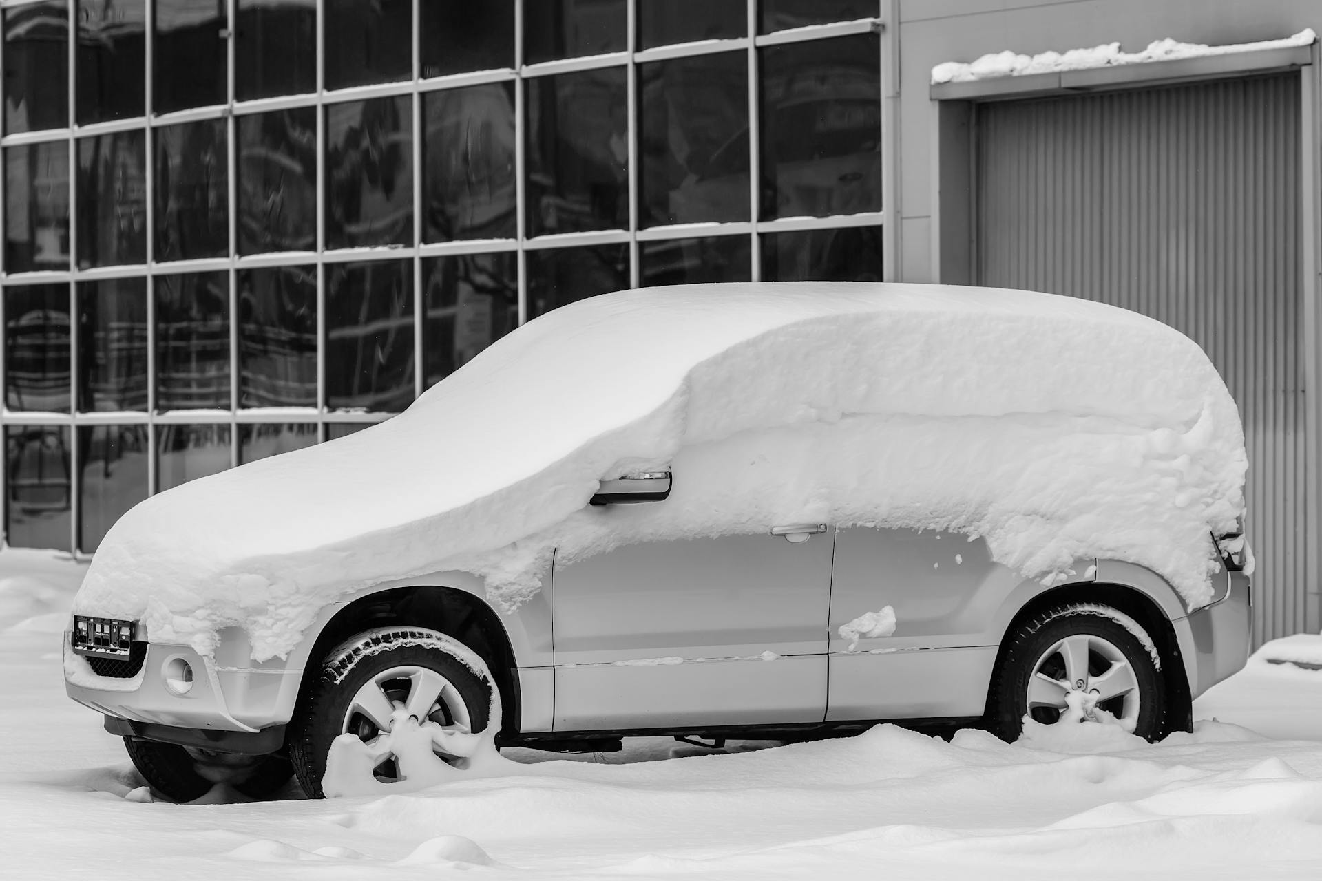 A Parked Gray Car Covered with Thick Snow