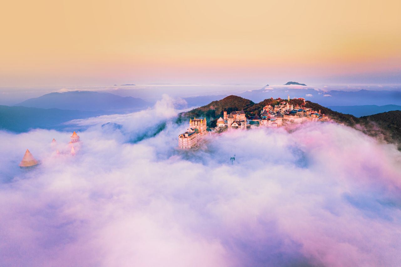 majestic aerial shot of a castle on a mountainous landscape shrouded i
