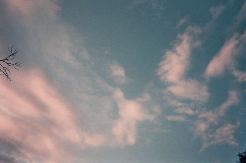 Free Soft pink clouds drift across a tranquil blue sky, capturing a serene evening moment. Stock Photo