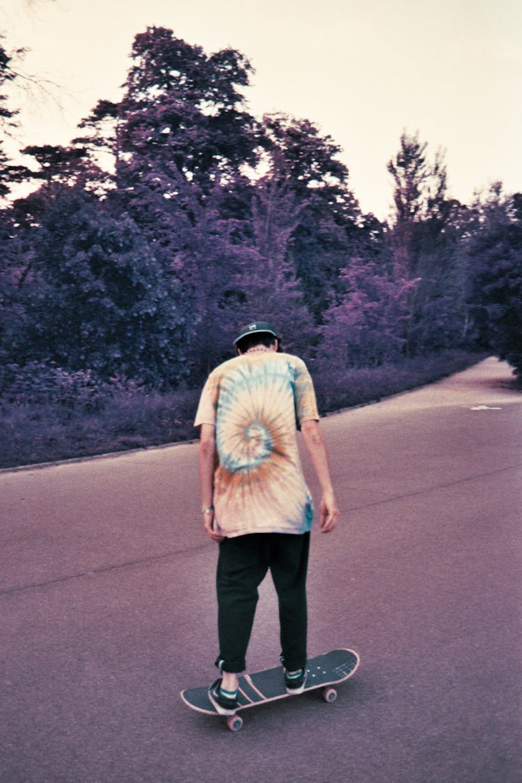 Teenage Boy Standing On Skateboard In Park