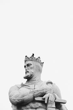 A striking black and white photo of a regal statue of a warrior king in Zaragoza, Spain, against a clear sky.