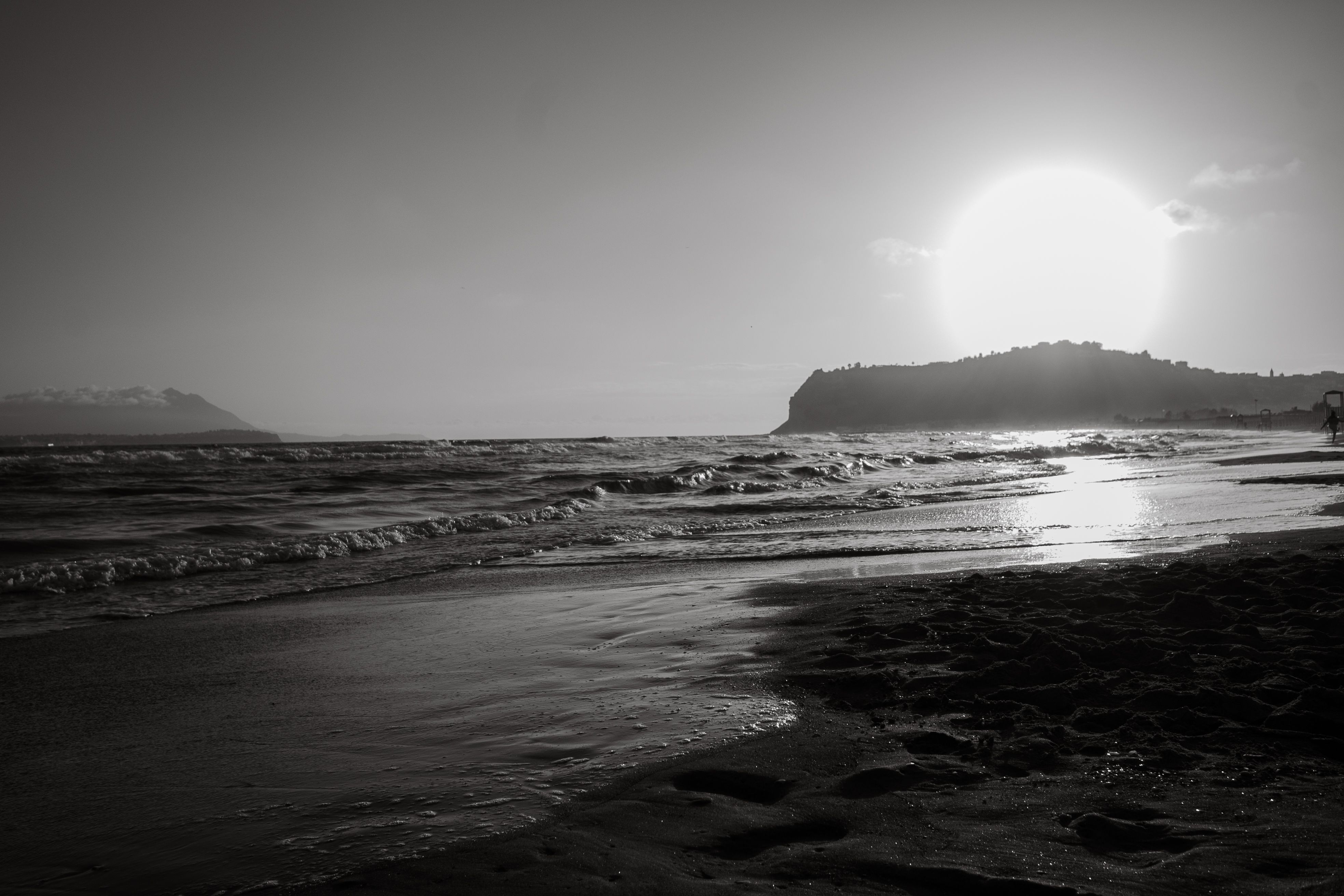 Captivating monochrome sunset view at Bacoli beach in Kampanien, Italy, capturing serene sea waves.