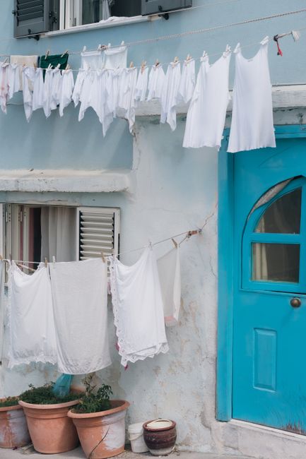 Charming Italian facade with drying laundry and vivid blue door.