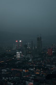 A captivating aerial view of Izmir cityscape illuminated at night, showcasing modern skyscrapers.