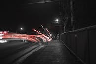 这张迷人的长曝光照片捕捉了夜间桥梁上的光痕，突显了运动与速度感