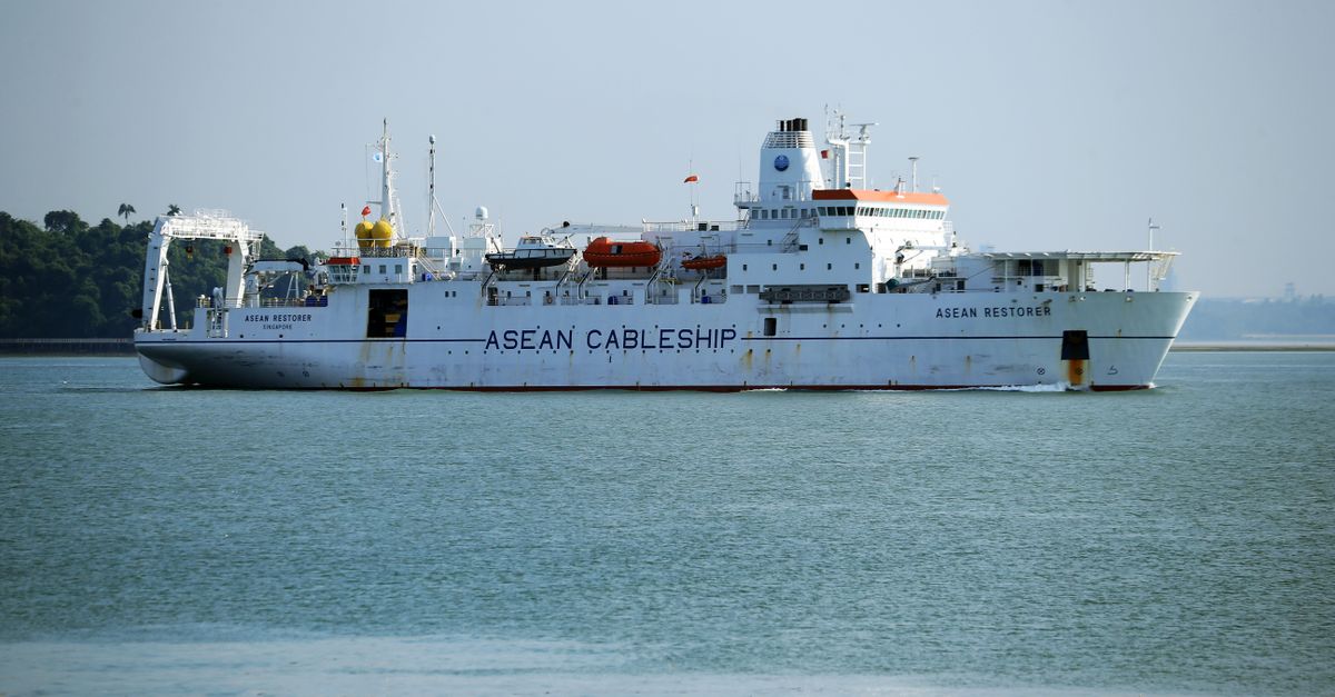 A cable ship named ASEAN Restorer navigating in clear ocean waters, highlighting maritime technology.