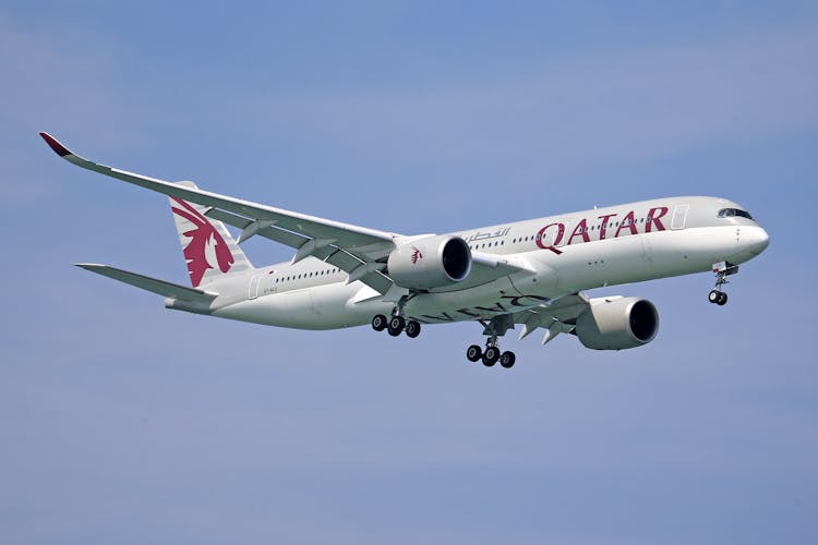 Qatar Airways Airplane Flying In The Blue Sky