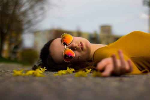 Free Closeup Photo of Woman Lying on Gray Pavement Stock Photo