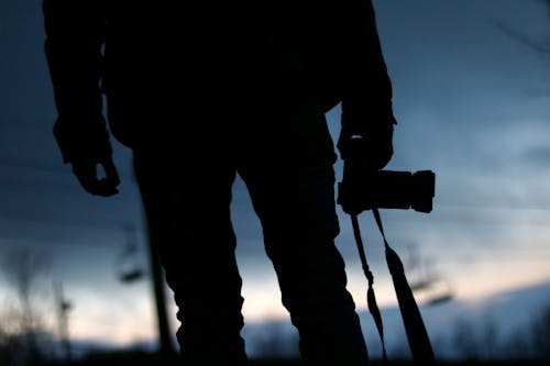 Silhouette of Person Holding Camera