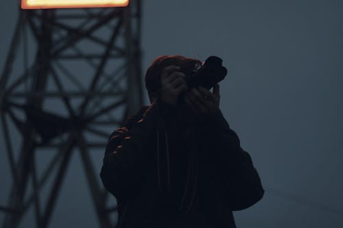 Silhouette Photography of Man Holding Dslr Camera