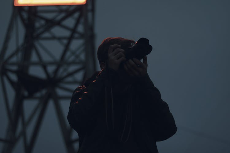 Silhouette Photography Of Man Holding Dslr Camera