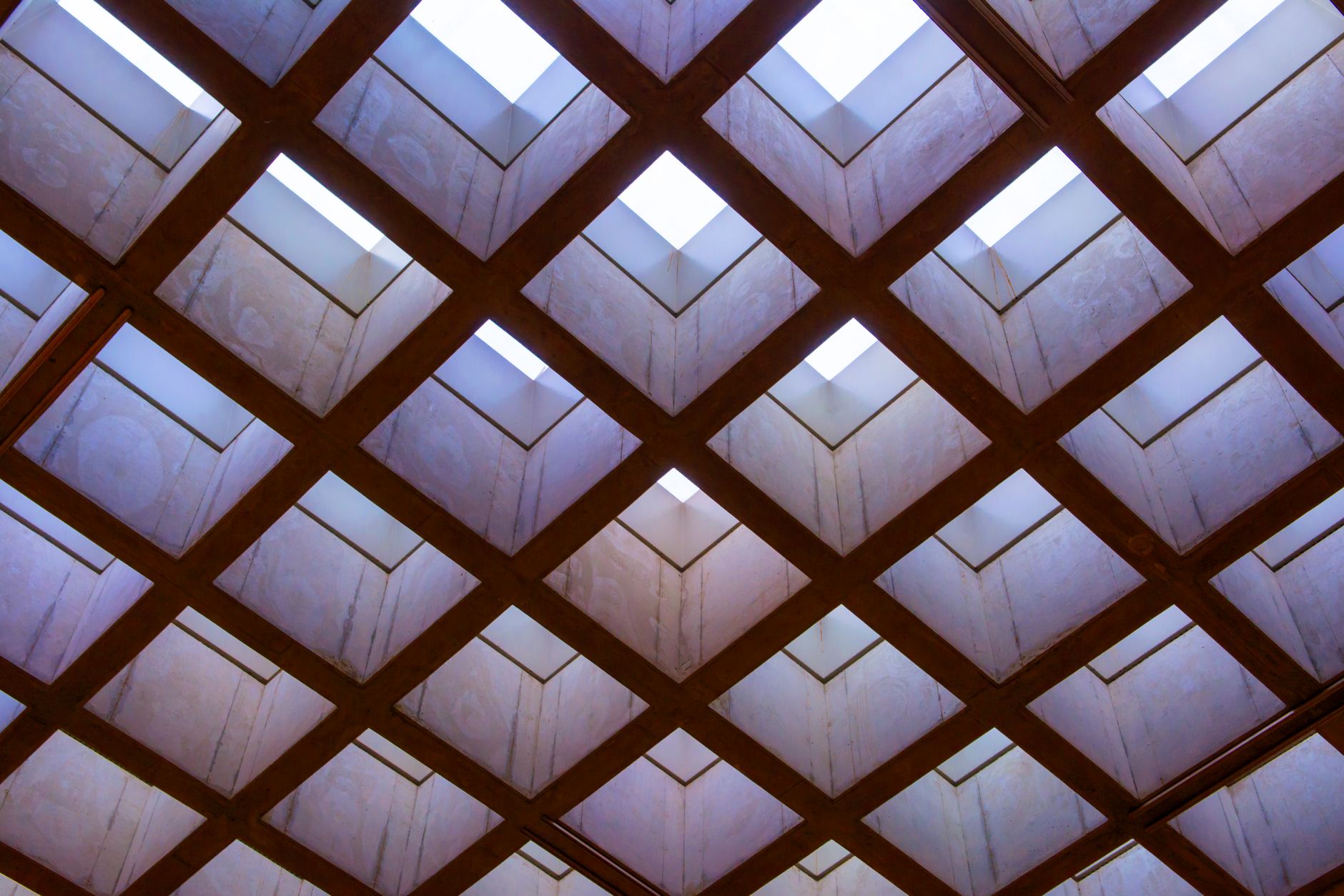 Low angle view of a symmetrical and geometric ceiling with skylights.