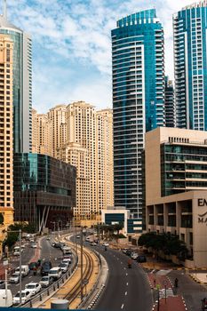 A vibrant cityscape of Dubai featuring tall skyscrapers and a bustling urban scene.