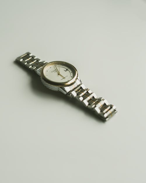 Silver and Gold Analog Watch on White Surface 