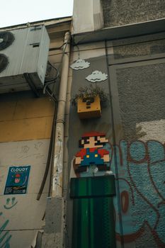 Colorful urban mural with a classic video game character and graffiti.
