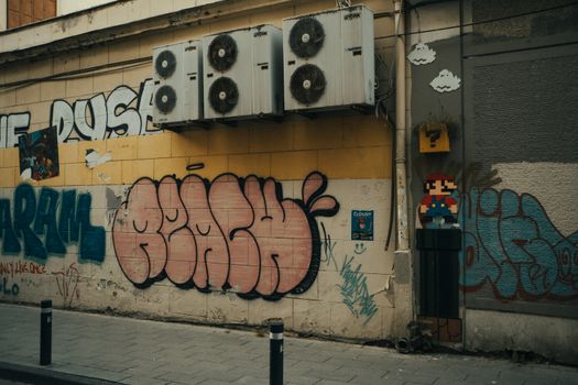 Vibrant street art featuring graffiti and pixelated Mario on an urban wall with wall-mounted air conditioners.