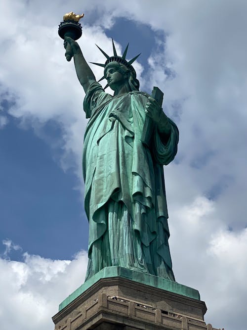 Photograph of the Statue of Liberty Under a Cloudy Sky