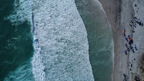 Aerial Shot of Waves Crashing on Seashore 