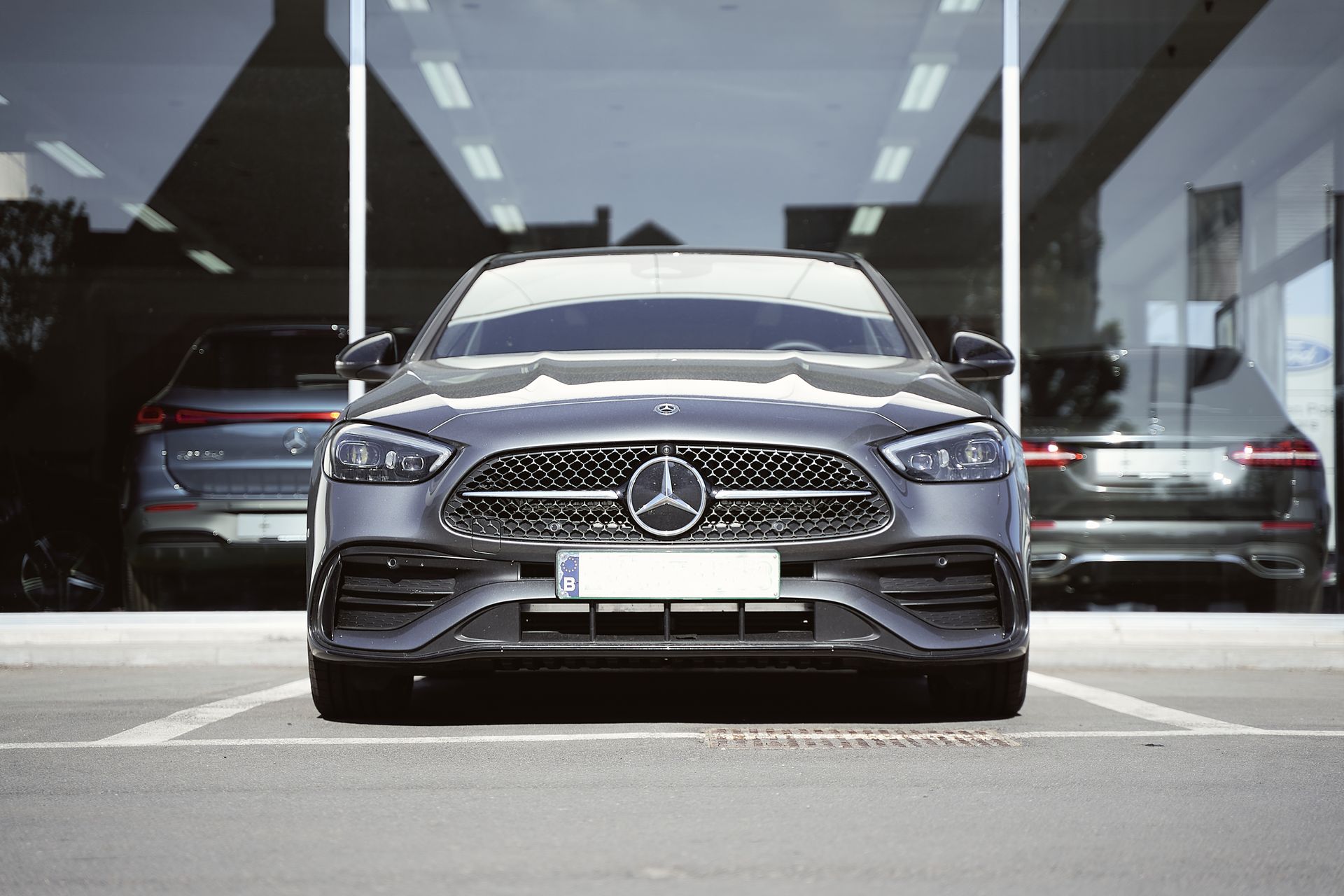 Front view of a sleek gray Mercedes-Benz sports car parked at an auto dealership.