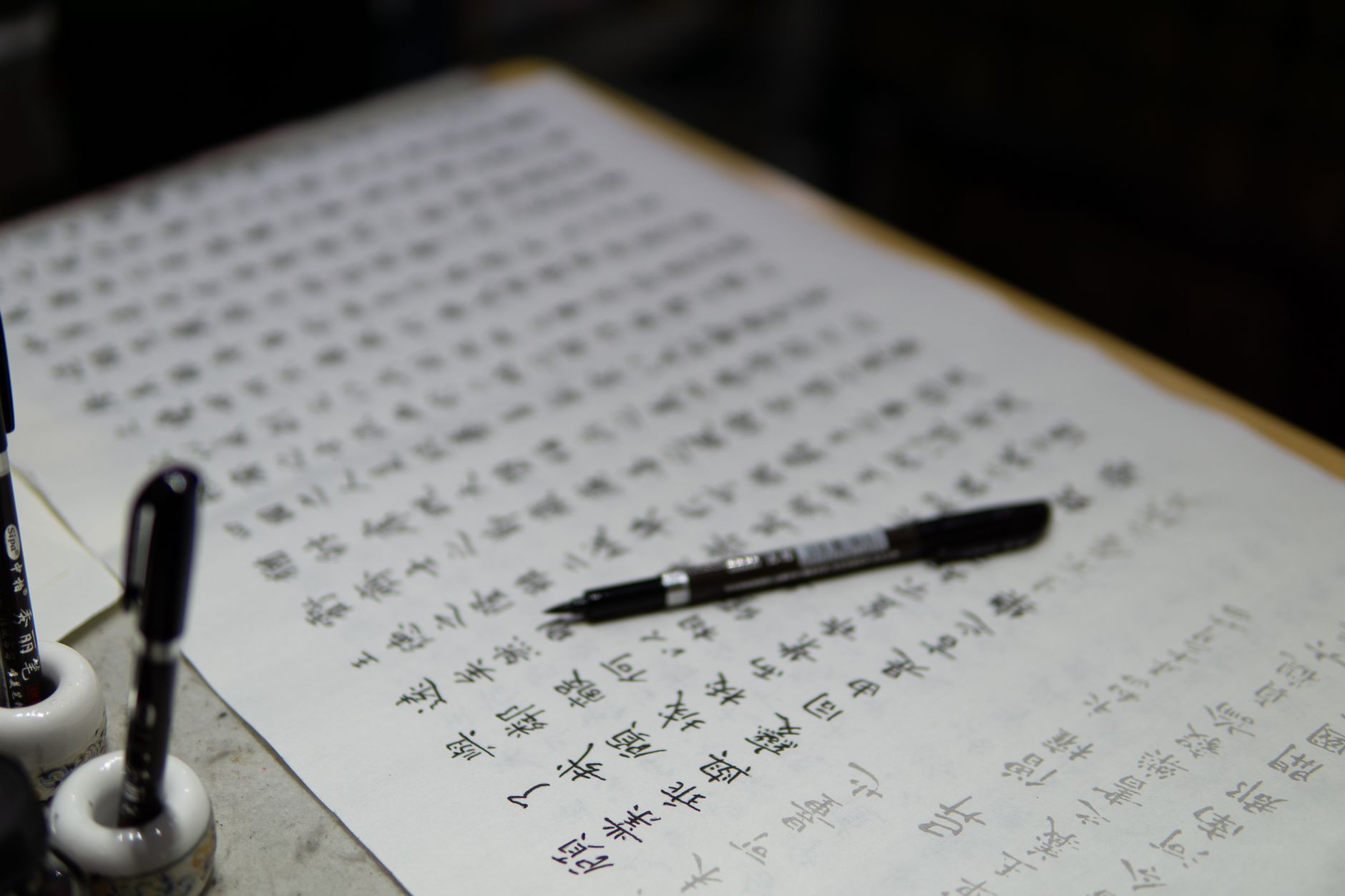 Detailed image of traditional Chinese calligraphy with ink pens and paper.