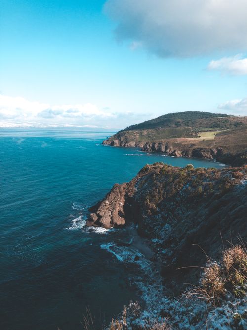 Free Scenic coastal view with dramatic cliffs and open sea under a clear blue sky. Stock Photo