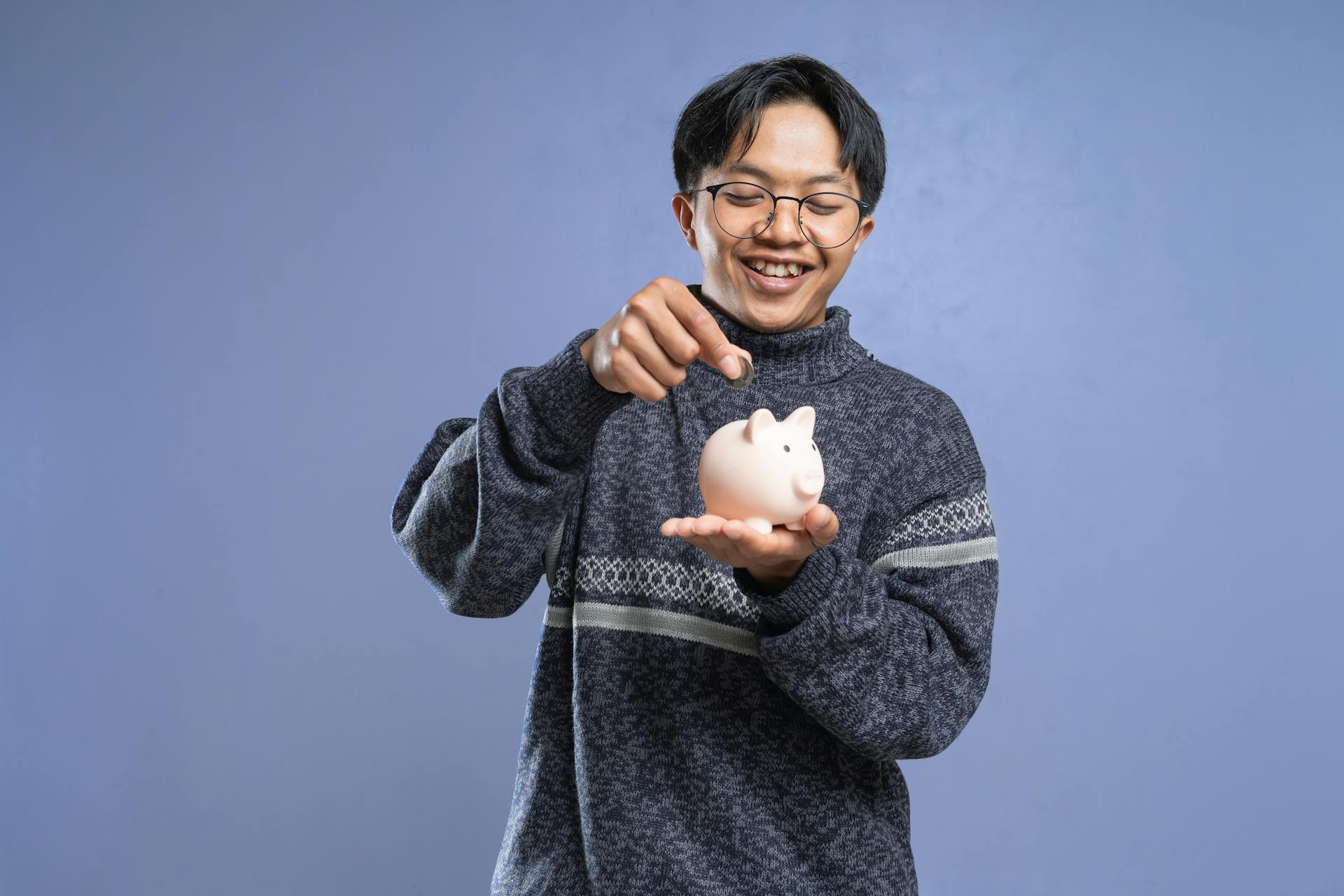 A Man Putting Coin in the Piggy Bank