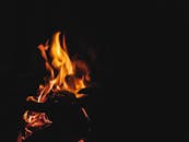 在黑暗背景的映衬下，明亮的橙色火焰令人着迷，唤起温暖而强烈的感受