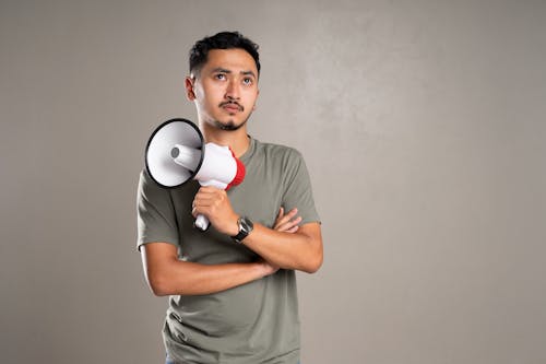 Man in Gray Crew Neck T-shirt Holding a White and Red Megaphone 