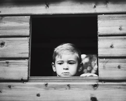 Darmowe zdjęcie z galerii z chłopak, czarno-biały, drewniane okno