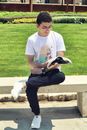 Man in White Crew Neck T-shirt Sitting on Brown Wooden Bench