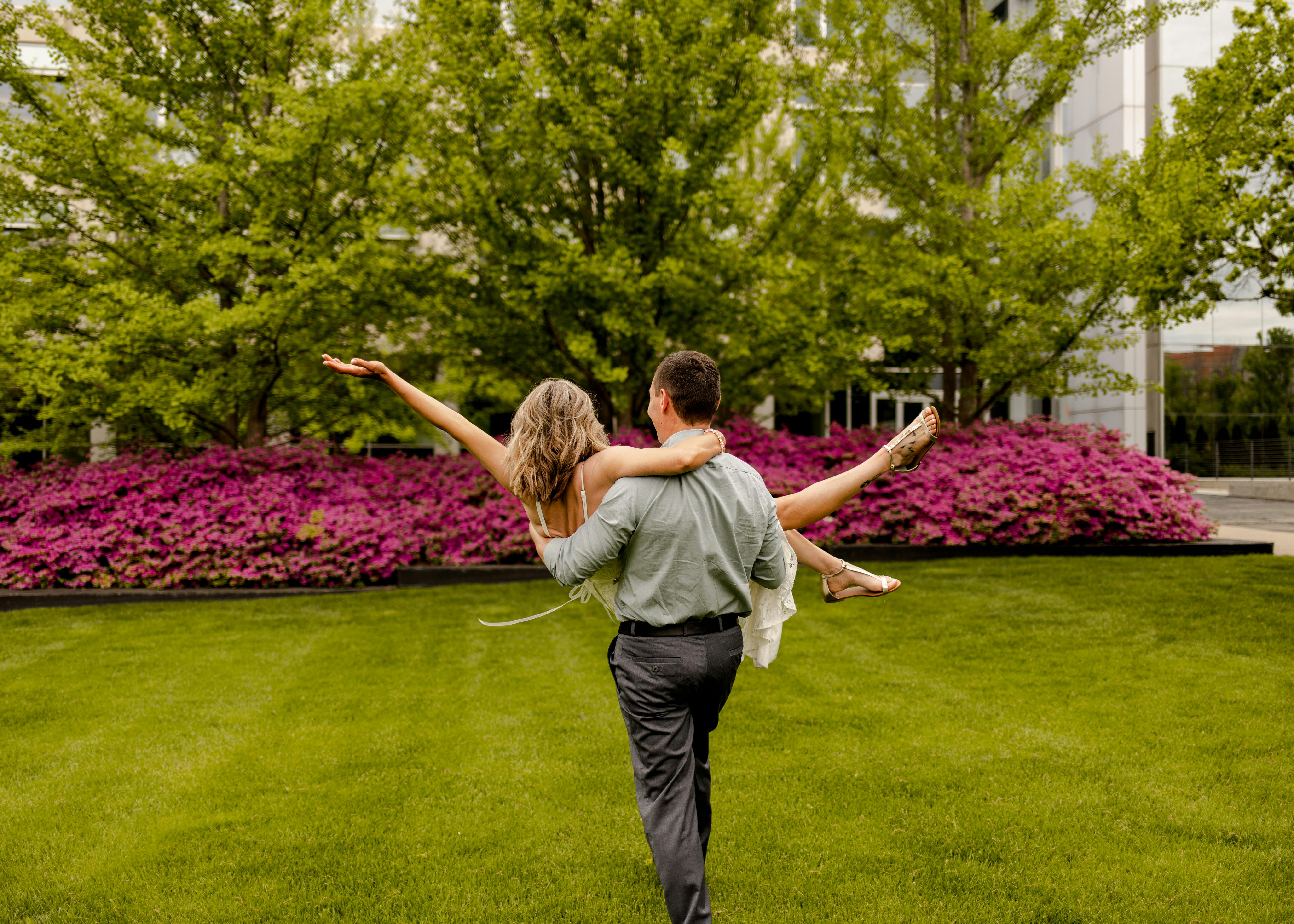 Bride and groom walking hand in hand through scenic gardens