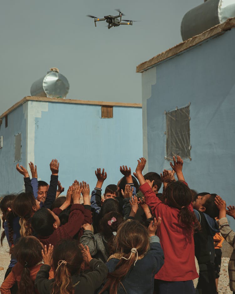 Group Of Children Cheering With Their Hands In The Air 