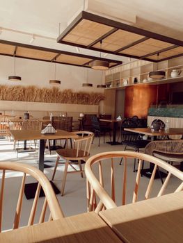 Warm and inviting restaurant interior featuring wooden chairs and tables under soft lighting.